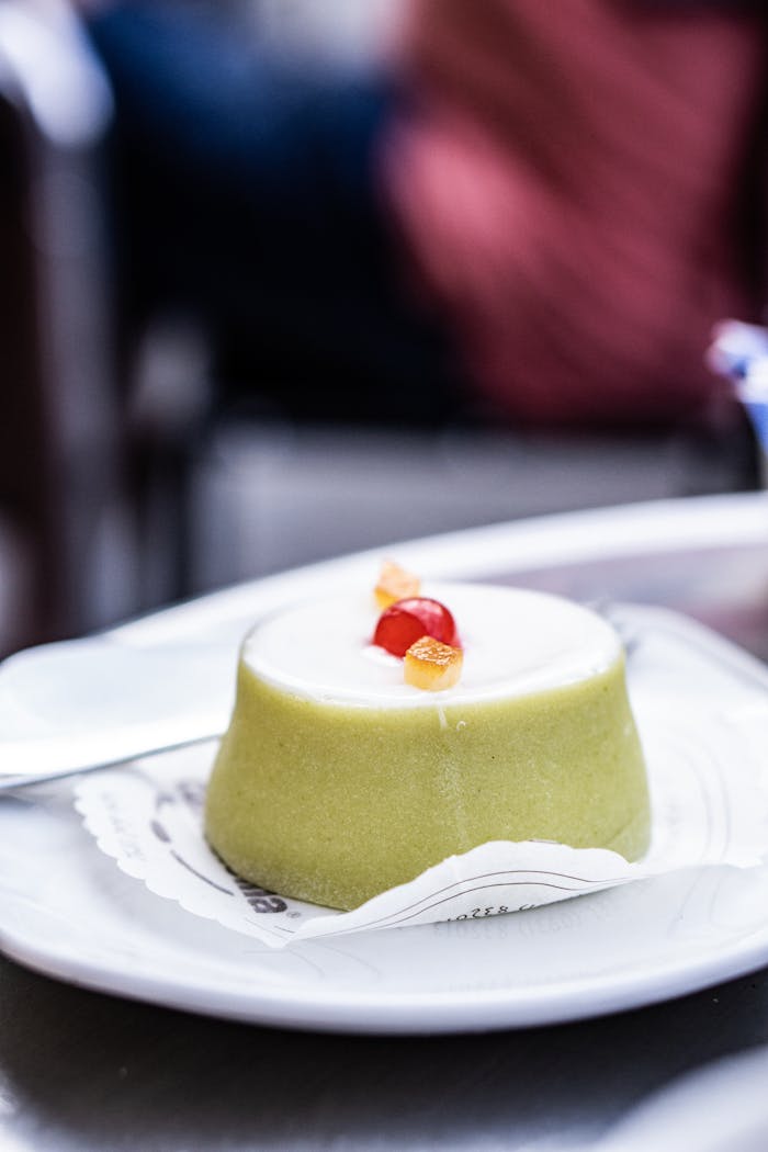 Close-up of a classic Cassata Siciliana dessert with candied fruits on a plate in Noto, Sicily.
